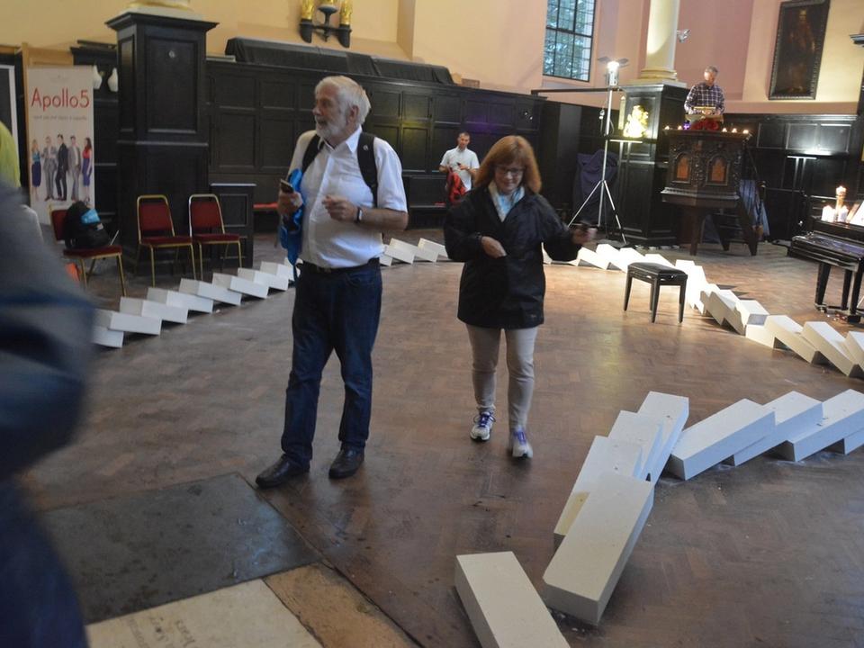 Visitors watching white blocks fall inside the church.