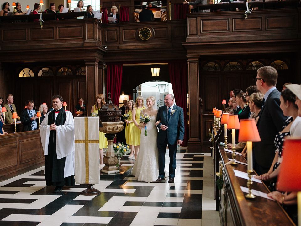 A wedding couple processing through the church as guests look on.
