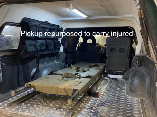 The rear of a pickup fitted with equipment to transport injured people.