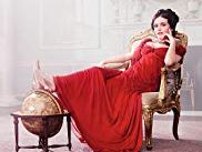 A Vanity Fair cover showing a woman in a red dress seated in a chair.