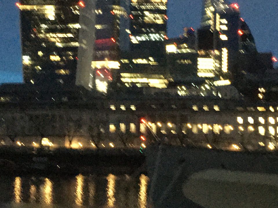 Illuminated office buildings beside the river at night.