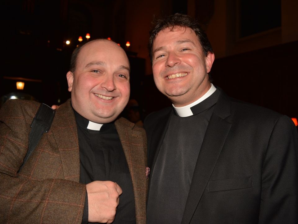 Two members of the clergy smiling together at a reception.