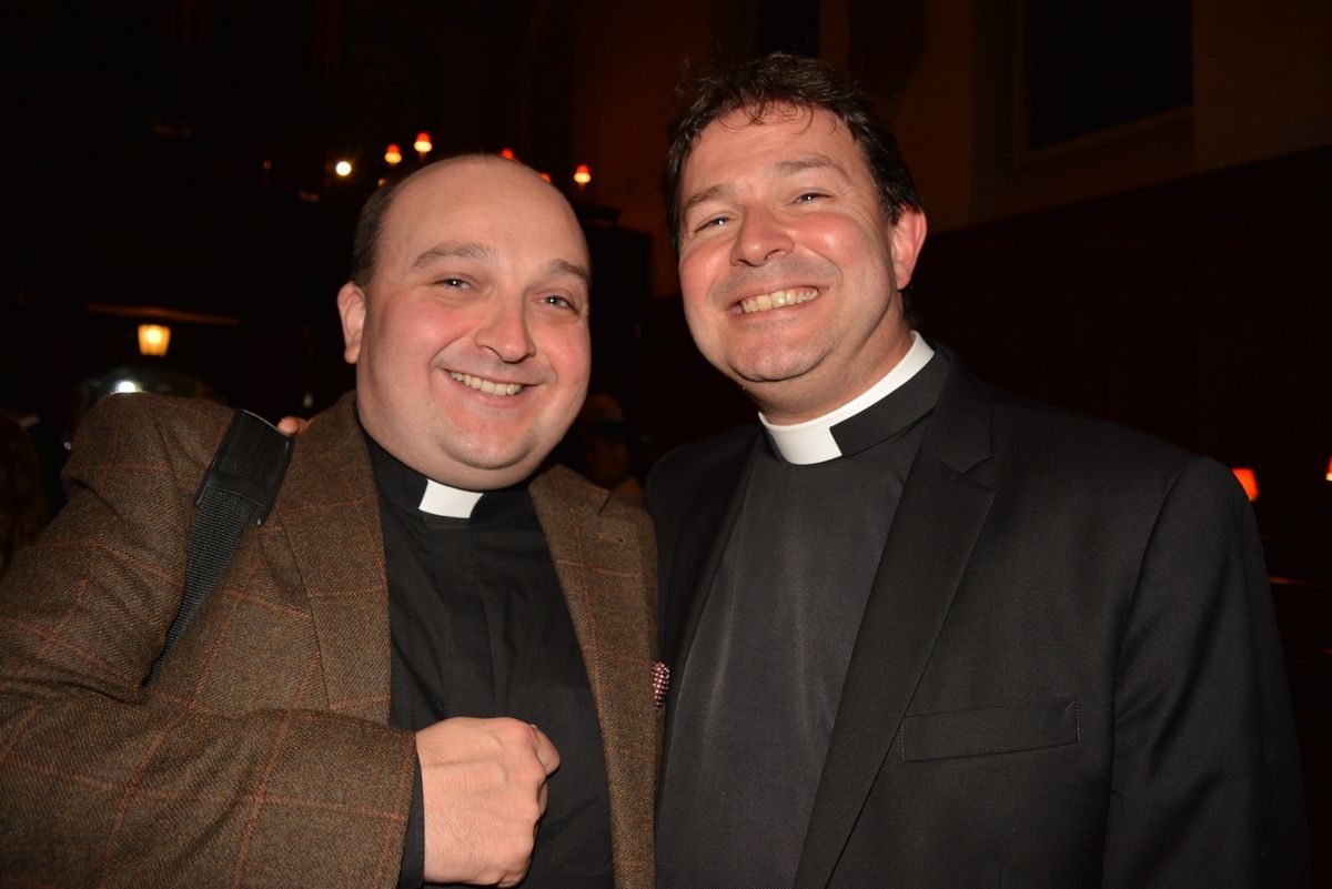 Two members of the clergy smiling together at a reception.