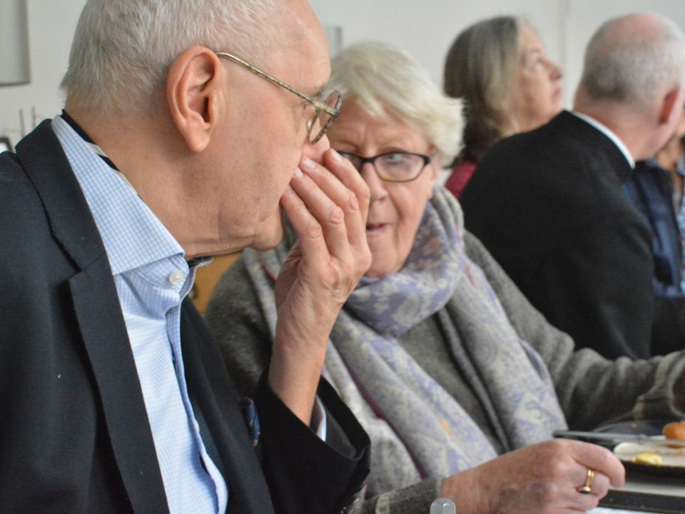 Two guests talking closely together at the breakfast table.