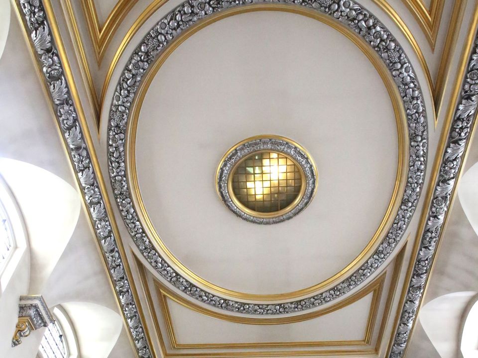 The oval centre of the decorated church ceiling with its gold ornament.
