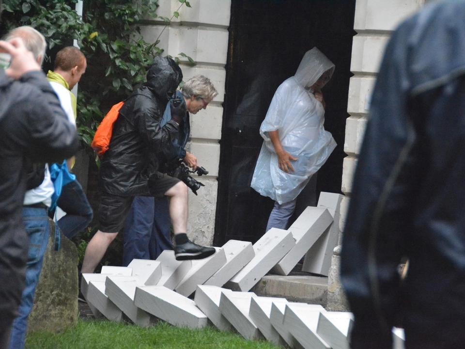 White blocks falling beside people standing at a church entrance.