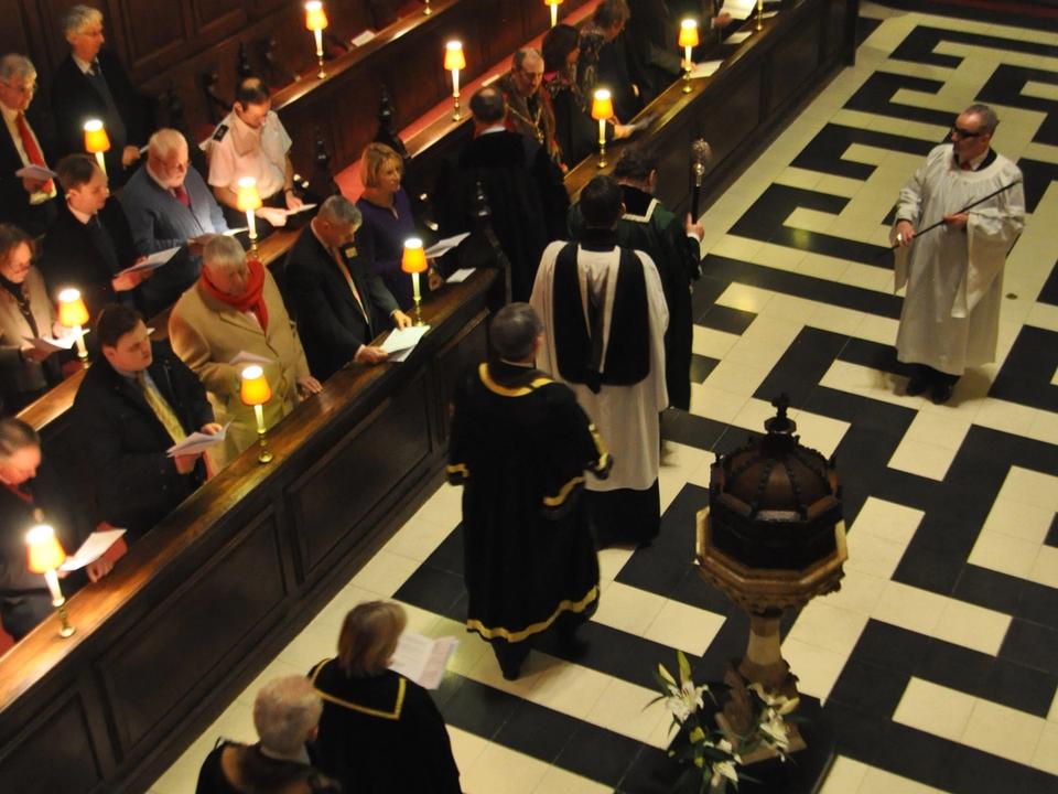 A service viewed from above, with clergy and congregation beside the central aisle.