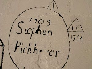 Handwritten names and dates on a plaster wall in the church tower.
