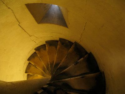 A narrow spiral staircase descending inside the church tower.