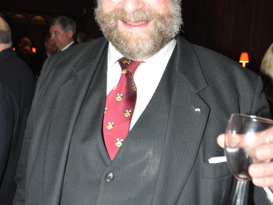 A formally dressed guest raising a glass at a reception.