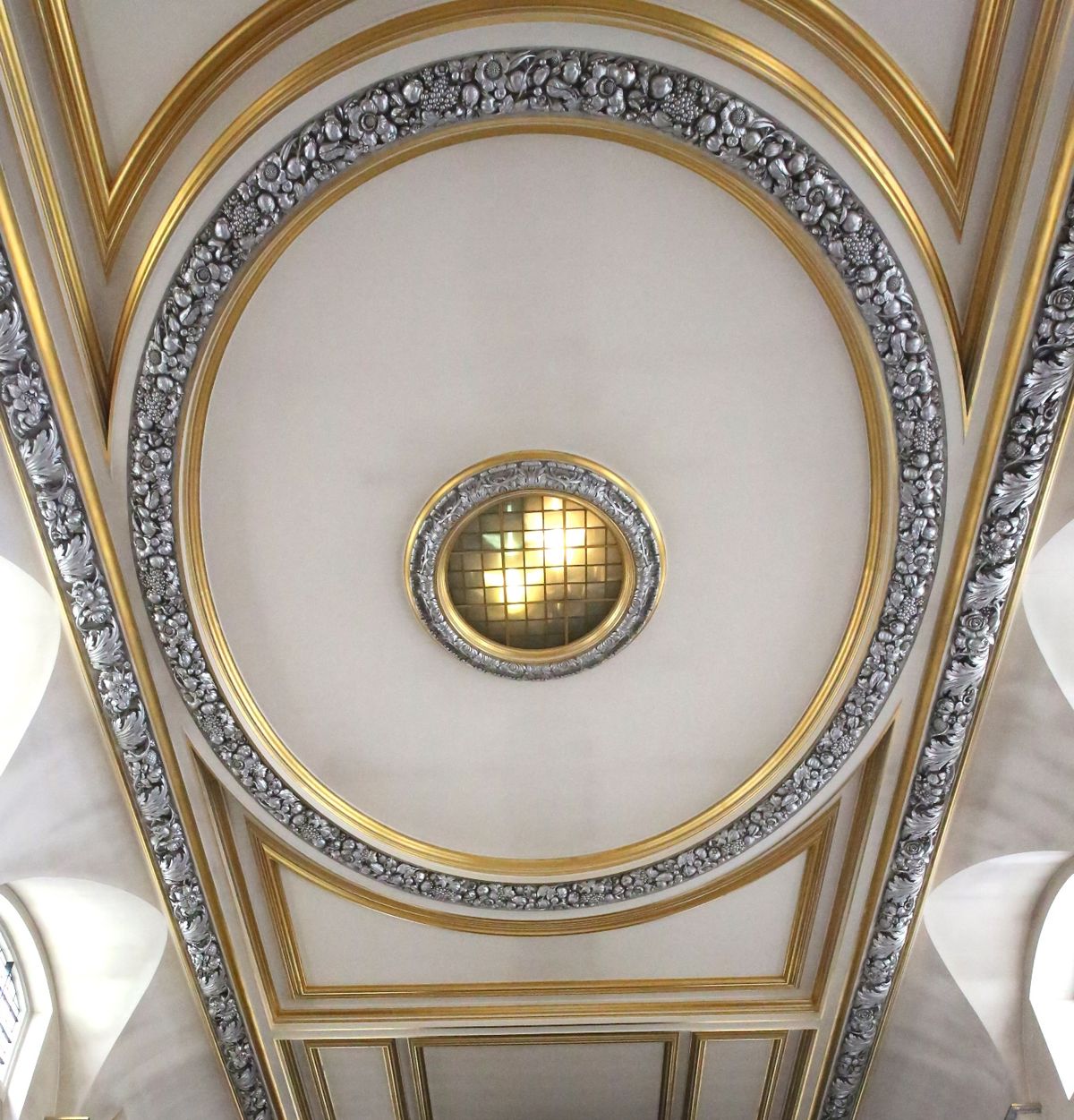 A view upwards at the church's oval ceiling and decorative border.