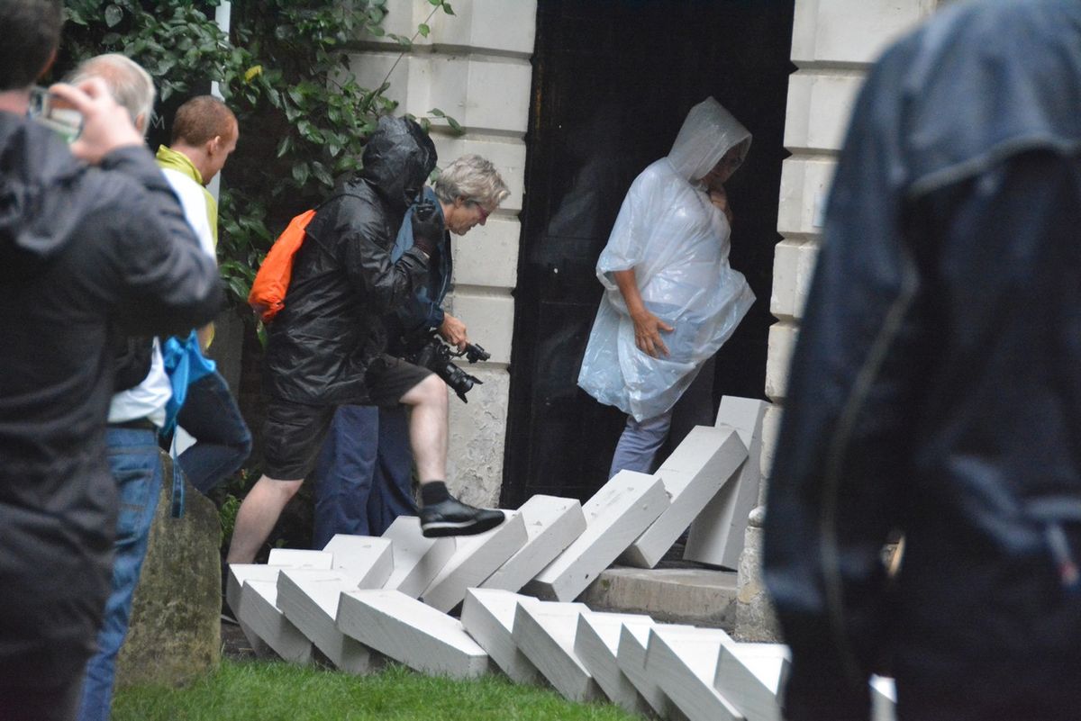 White blocks falling beside people standing at a church entrance.
