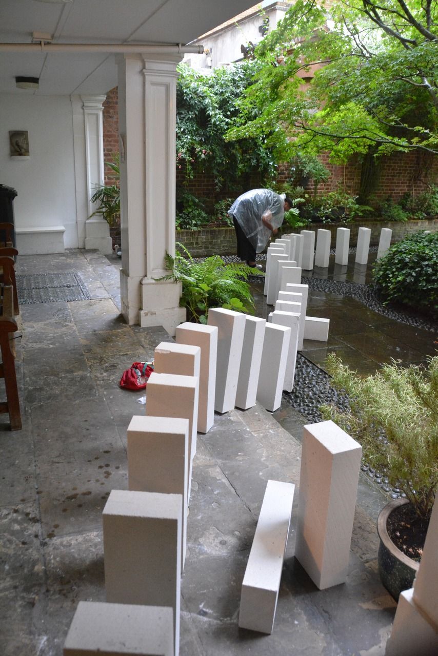 White rectangular blocks arranged along a path around the courtyard tree.