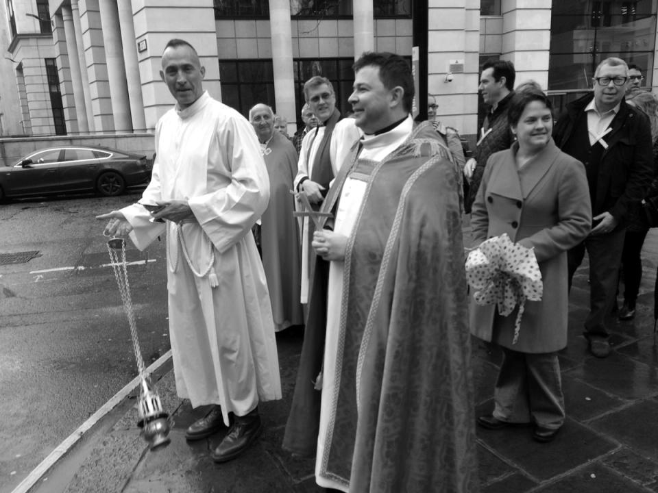 Clergy and worshippers standing together during an outdoor procession.
