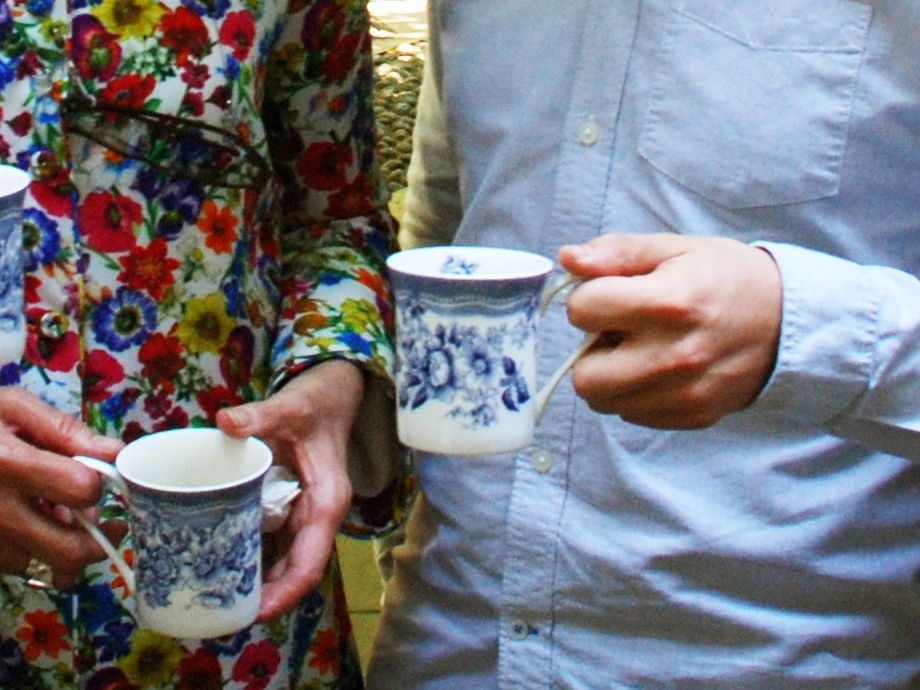 Guests holding mugs during a church coffee gathering.