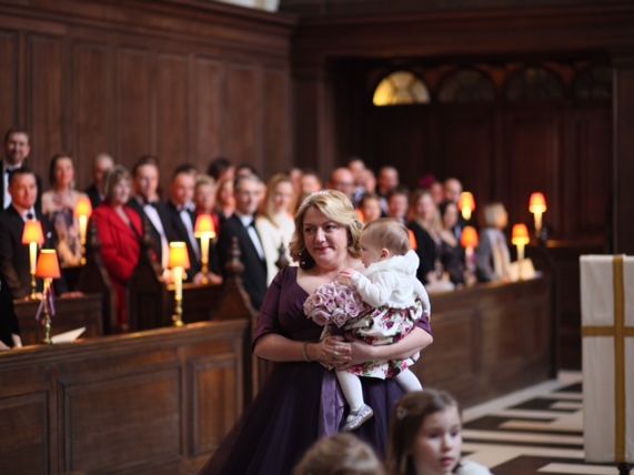 A bride in a purple dress holding a bouquet inside the church.