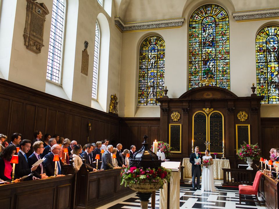 A wedding couple processing down the aisle past the seated congregation.