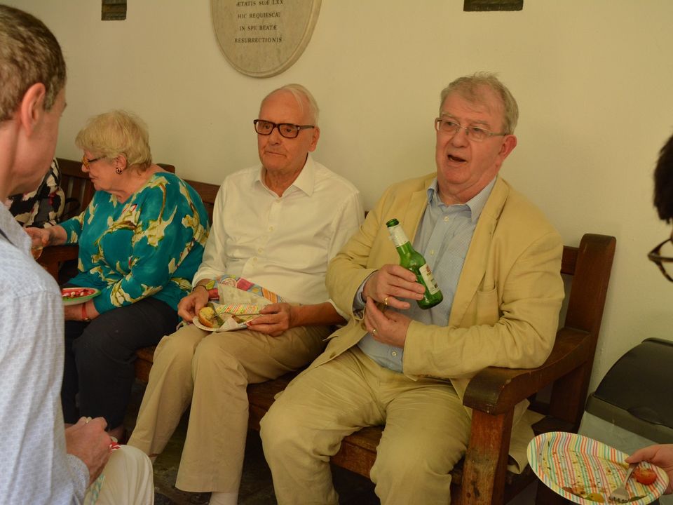 Three seated guests chatting and holding drinks.