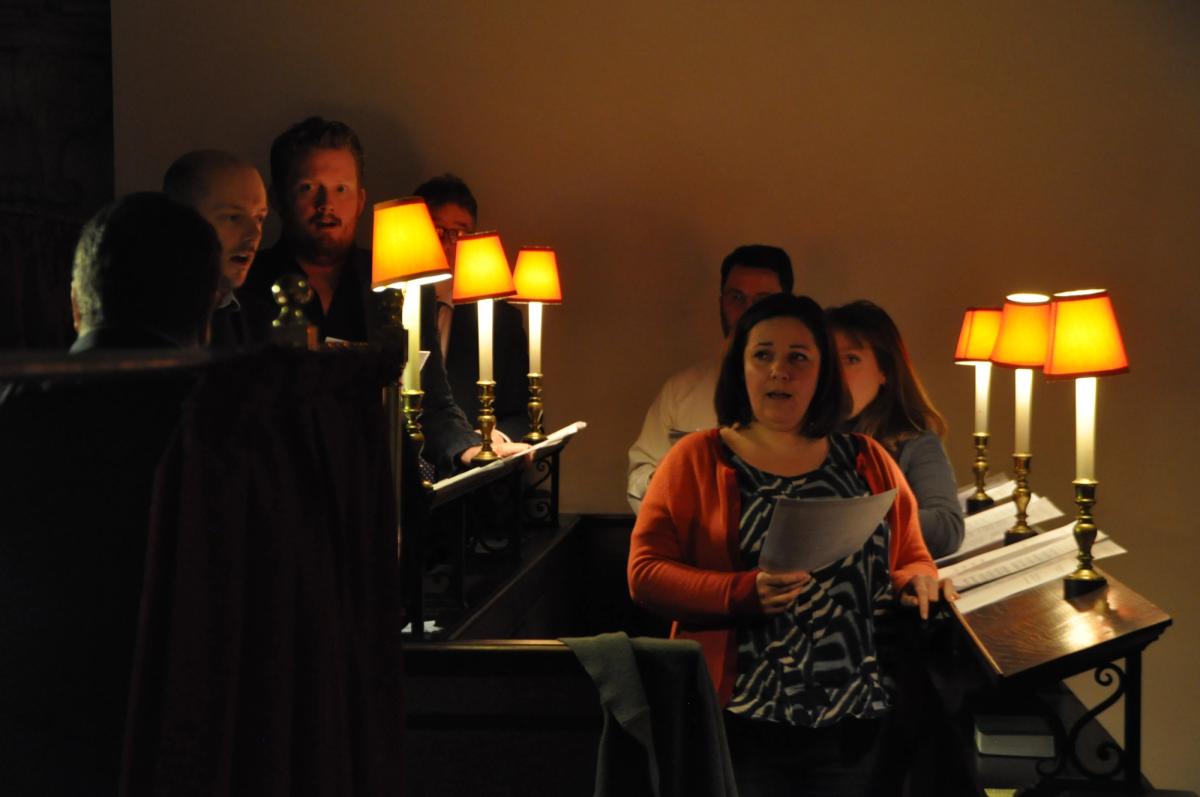 Members of the congregation seated beside glowing pew lamps.