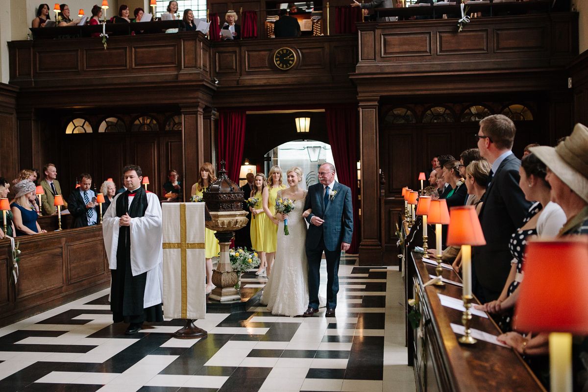 A wedding couple processing through the church as guests look on.