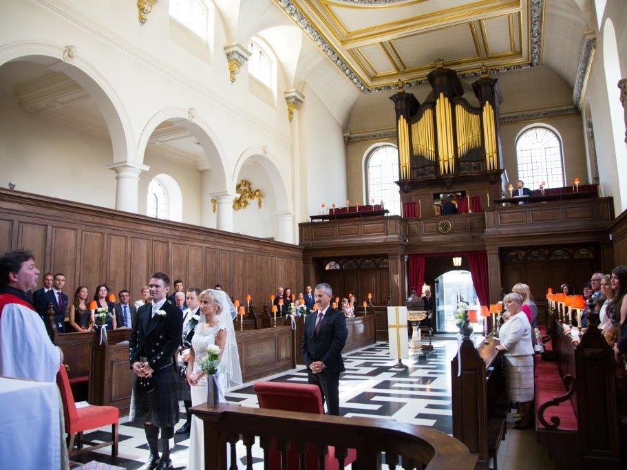 Wedding guests gathered beneath the organ gallery during a service.