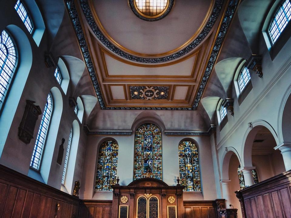 A wide view of the church ceiling, windows and altar.