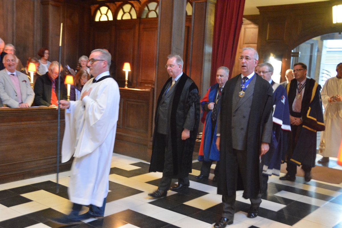 Clergy and formally dressed guests standing inside the church during a service.