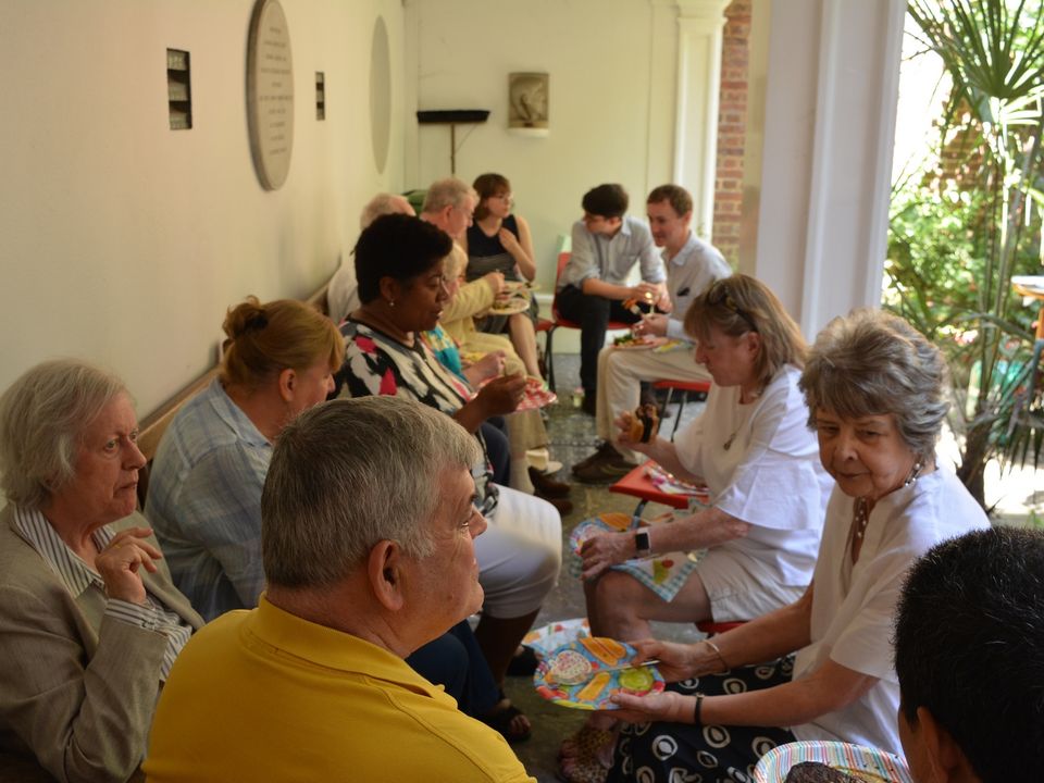 Guests seated along the walls of the courtyard, eating and talking.