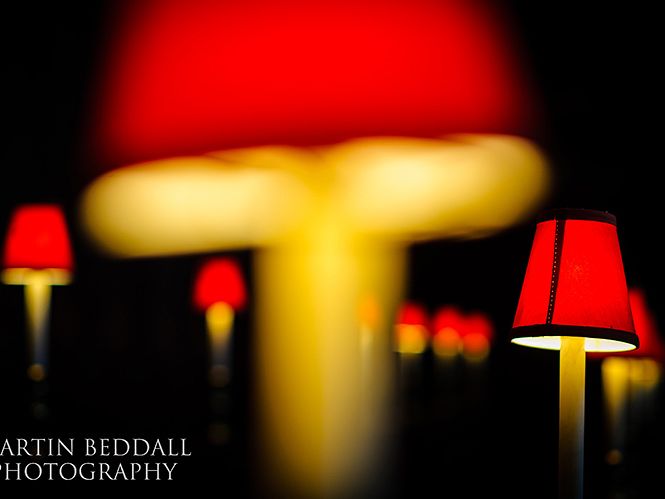 A close-up of the church's red-shaded pew lamps.