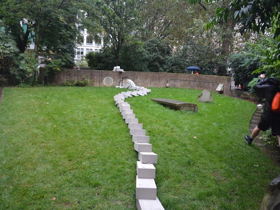 A winding line of fallen white blocks across a lawn.
