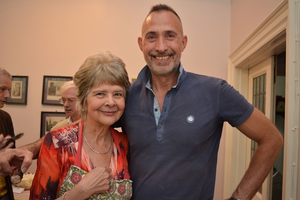 Two guests smiling together at an indoor parish gathering.