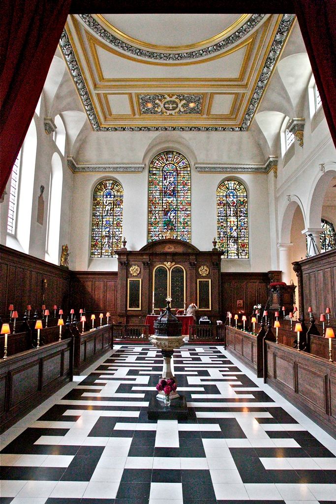St Vedast's patterned central aisle leading towards the altar and stained-glass windows.