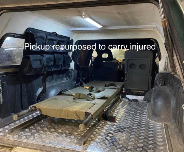 The rear of a pickup fitted with equipment to transport injured people.